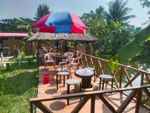 un patio con mesa, sillas y sombrilla en Banorupa Kuakata hotel, en Kuākāta