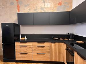 a kitchen with a black counter top and wooden cabinets at Apartamenty Rynek 18 in Żywiec
