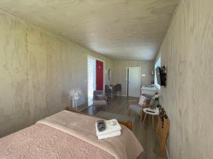 a bedroom with a bed and a living room at Cotman Cottage on Coatesville in Kumeu