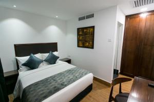 Säng eller sängar i ett rum på Belllo Hotel JB Central