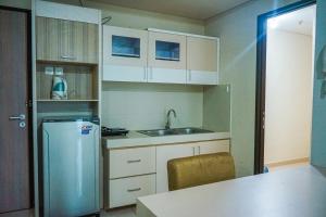 a small kitchen with a sink and a refrigerator at Apartemen Solo Center Point in Bonorejo