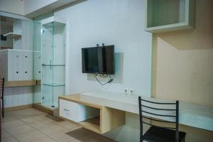 a kitchen with a desk with a television on the wall at Apartemen Solo Center Point in Bonorejo