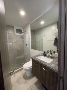 a bathroom with a toilet and a sink and a shower at Elegante apartamento en condominio cerca del aeropuerto 