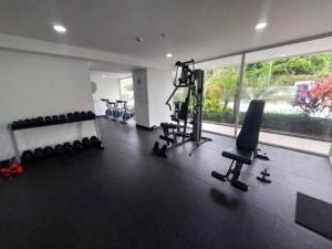 een fitnessruimte met loopbanden en fitnessapparatuur in een kamer bij Elegante apartamento en condominio cerca del aeropuerto 