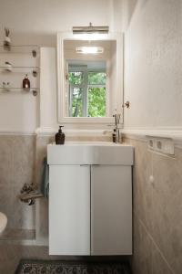 a white bathroom with a sink and a window at 20 stairs in Vilnius +51 photos