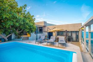 a swimming pool with two chairs and a table at Çimentepe Residence Deluxe 1 - Villa with Heated Pool & Close to Yalikavak Marina in Bodrum City