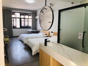 a hotel room with two beds and a mirror at Hetao B&B in Tongxiang