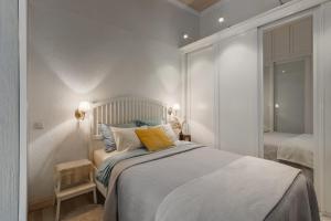 a white bedroom with a bed with a yellow pillow at 20 stairs in Vilnius