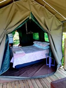 - un lit dans une tente en toile dans l'établissement Chosen Glamping Tents, à Graskop