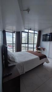 a bedroom with a large bed with a large window at HOTEL REAL PLAZA in Cajamarca