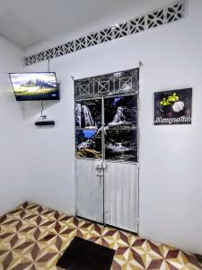 Habitación con puerta y TV en la pared en SAN SENDERISMO ROOM en Mariquita