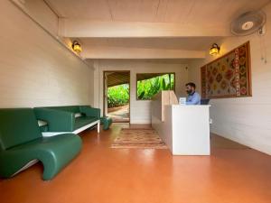 a man at a counter in a room with green chairs at Habitus - Mandrem in Mandrem