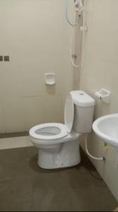 a bathroom with a white toilet and a sink at Homestay Taman Tiara Paka Full AC Free Wi-fi & COWAY in Paka