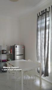 a white table and chairs in a kitchen with a window at Homestay Taman Tiara Paka Full AC Free Wi-fi & COWAY in Paka