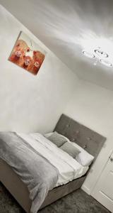 a bed in a white room with a poster on the wall at ARIEL LUXURY APARTMENT in London