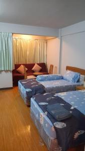 a room with four beds and a couch at Victory view rayong beach in Ban Chamrung