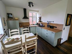 a kitchen with a table and a table and chairs at Alter Kornspeicher im Münsterland in Greven
