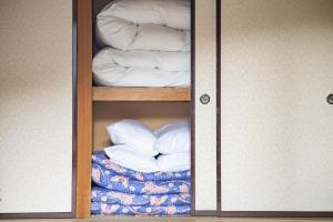 a closet with a glass door with towels and blankets at Yuzawa house in Yuzawa