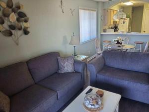 een woonkamer met 2 banken en een tafel bij Tilghman Shores D9 in Myrtle Beach