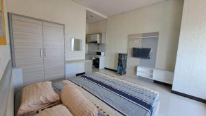 Il comprend une grande chambre avec un lit et une cuisine. dans l'établissement Apartemen Sentraland Semarang, à Semarang