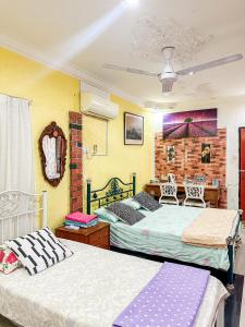 a bedroom with two beds and a brick wall at Dusun Indah Cottage 1 in Bayan Lepas