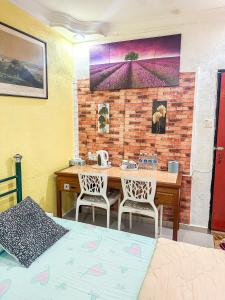 Dusun Indah Cottage 1 في بايان ليباس: غرفة مع طاولة وكراسي وجدار من الطوب