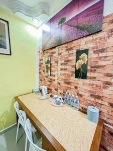 a wooden table with chairs and a brick wall at Dusun Indah Cottage 1 in Bayan Lepas