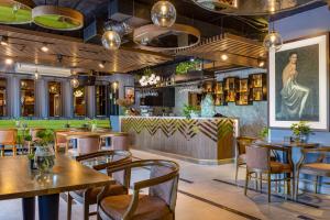 a restaurant with tables and chairs and a bar at Cat Ba Paradise Hotel - Travel Agency in Cat Ba