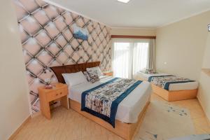 a hotel room with two beds and a wall at Andalusia Blue Beach Hurghada in Hurghada