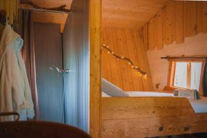 a bedroom with a bed in a wooden cabin at Cabane Chalet avec spa privatif in Charnay