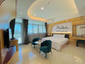 um quarto de hotel com uma cama, uma mesa e cadeiras em Wind Sea Hill Inn em Hengchun Old Town