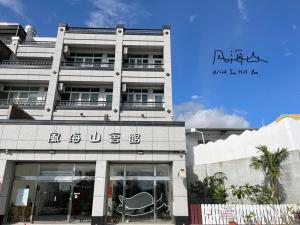 a white building with writing on the side of it at Wind Sea Hill Inn in Hengchun