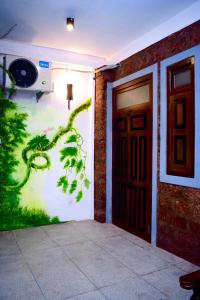 una stanza con un dipinto sul muro accanto a una porta di City Hostel Colombo Airport a Katunayake