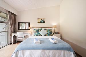 1 dormitorio con 1 cama con 2 toallas en Admirals Lodge Guest House, en Port Elizabeth