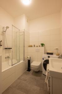 y baño con aseo, ducha y lavamanos. en maremar - Style Apartment im Zentrum - Luxus Boxspringbett - Arbeitsplatz - Highspeed WLAN en Gera
