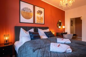 um quarto com uma cama grande e paredes cor-de-laranja em maremar - Style Apartment im Zentrum - Luxus Boxspringbett - Arbeitsplatz - Highspeed WLAN em Gera