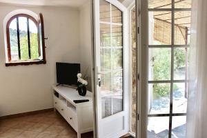 um quarto com uma secretária, uma televisão e uma janela em Gite l'Ortal avec piscine & SPA em Générargues