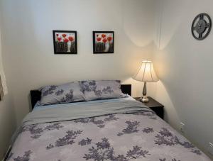 a bedroom with a bed and three pictures on the wall at Brand New One Bedroom Suite in Calgary