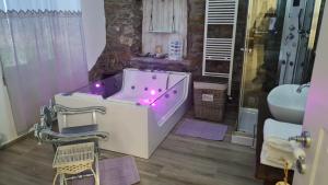 y baño con bañera con luces moradas. en Tana della Lavanda en Montefiorino