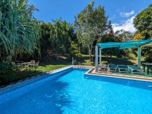 uma piscina com um gazebo e uma piscina em Green View Villa em Hikkaduwa