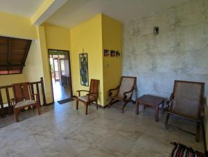 a living room with chairs and a room with yellow walls at Green View Villa in Hikkaduwa