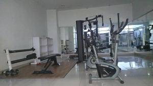 ein Fitnessstudio mit mehreren Trainingsgeräten in einem Raum in der Unterkunft Apartemen Student Castle Yogyakarta in Seturan