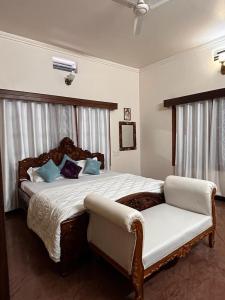 ハッサンにあるAmayaa Courtyard Homestayの大きなベッドと椅子のある寝室 +34枚の写真