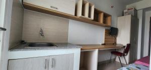 eine kleine Küche mit einem Waschbecken und einem Schreibtisch in der Unterkunft Apartemen Student Castle Yogyakarta in Seturan + 4 Fotos