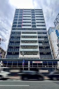 大阪市にあるApartment Hotel 11 Namba-Minami Ebisucho-Eki Maeの車が目の前を走る高層ビル