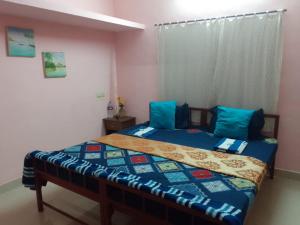 - une chambre avec un lit doté de draps bleus et d'oreillers bleus dans l'établissement Varkala Days Home Stay, à Varkala