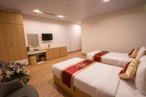 a hotel room with two beds and a television at Interstella Hotel in Da Lat