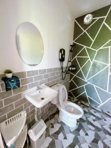 een badkamer met een wastafel, een toilet en een spiegel bij ฮักดอยคาเฟ่ แคมป์&โฮมสเตย์ สะพานสายรุ้ง จ.น่าน in Chiang Klang
