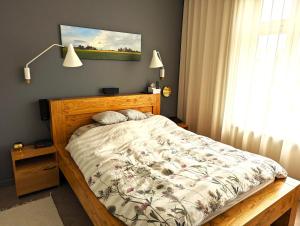 ein Schlafzimmer mit einem Bett mit einem Holzrahmen in der Unterkunft Sissi Apartment Aleksandri 32 in Tartu