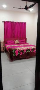 un lit rose avec une tête de lit rose dans une chambre dans l'établissement Varkala Days Home Stay, à Varkala